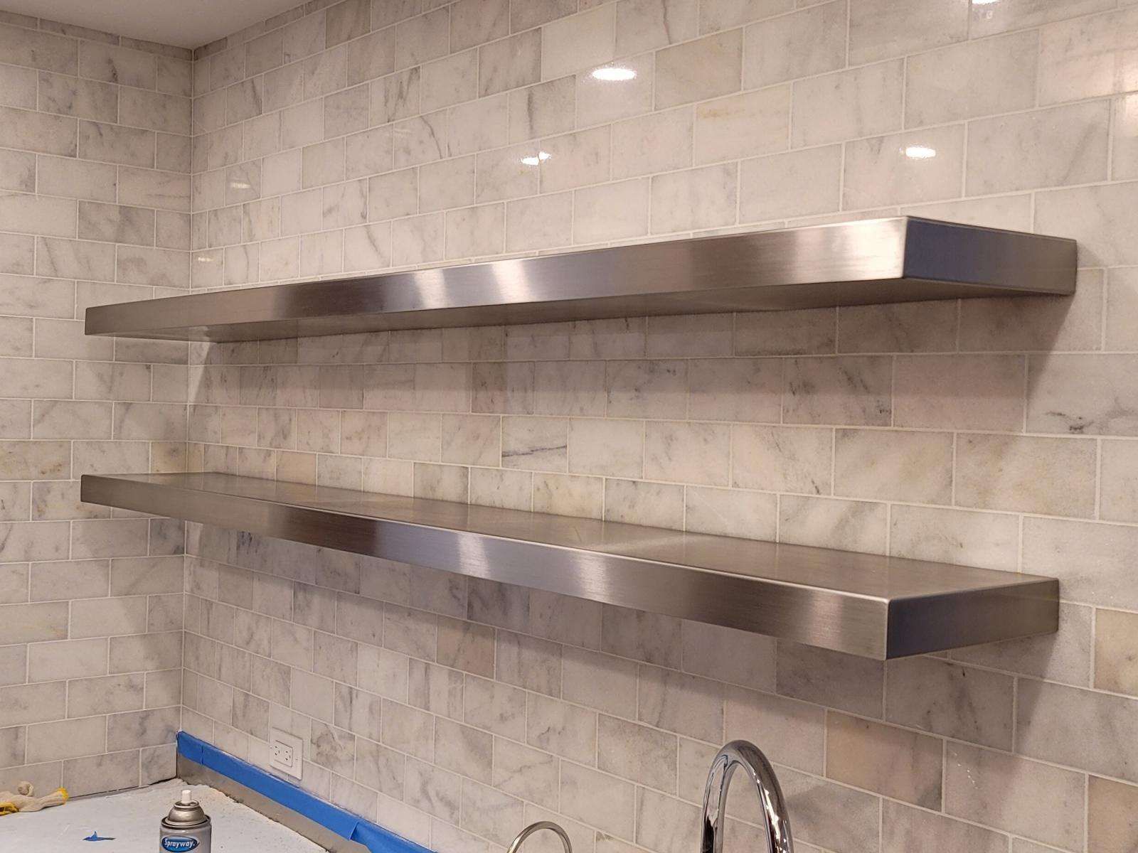 Stainless steel floating shelves on marble tile
