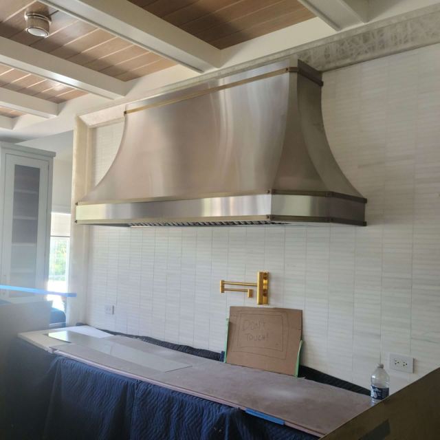 Custom Metal Home range hood. RH-2 with extra curve. Body: Stainless steel with matte finish. Straps: Copper with matte finish
