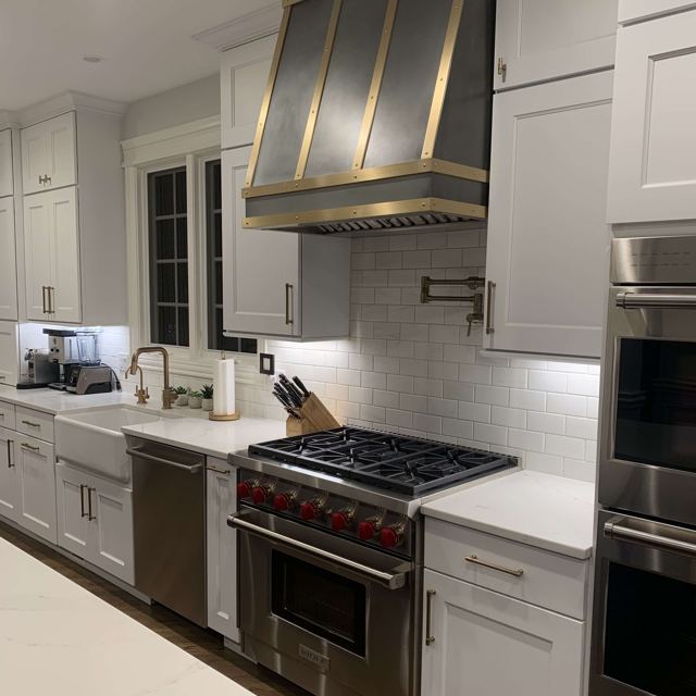 Custom Metal Home range hood. RH-4. Body: Zinc with dark patina. Straps: Brass with brushed finish