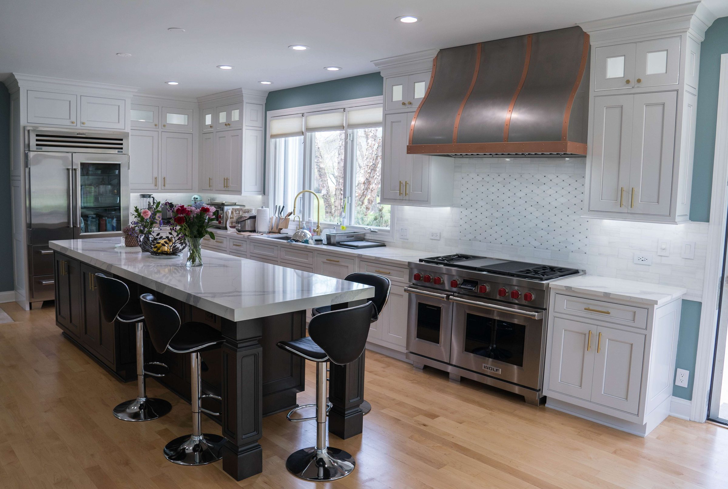 Custom copper and darkened steel range hood with brass banding in a large open kitchen, Custom Metal Home