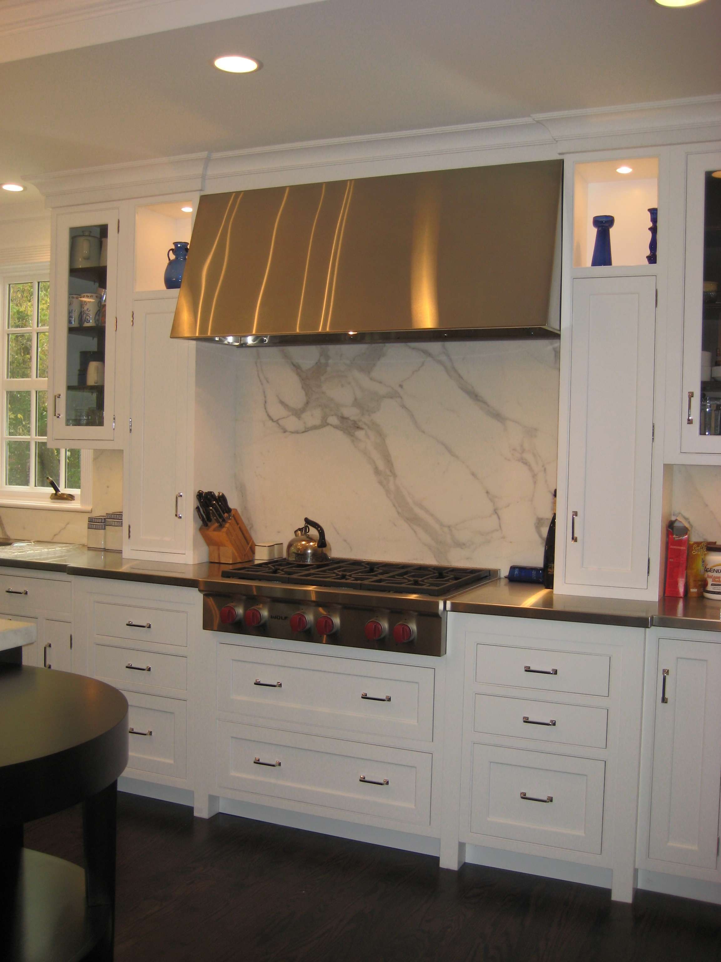 RH-4 stainless steel range hood with matching stainless countertops in a residential kitchen by Custom Metal Home