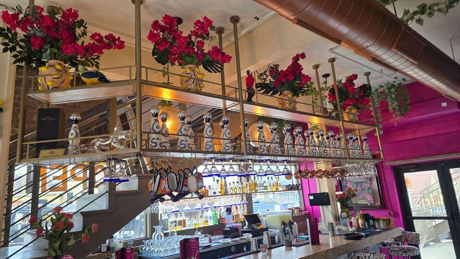Suspended brass shelving over a restaurant bar