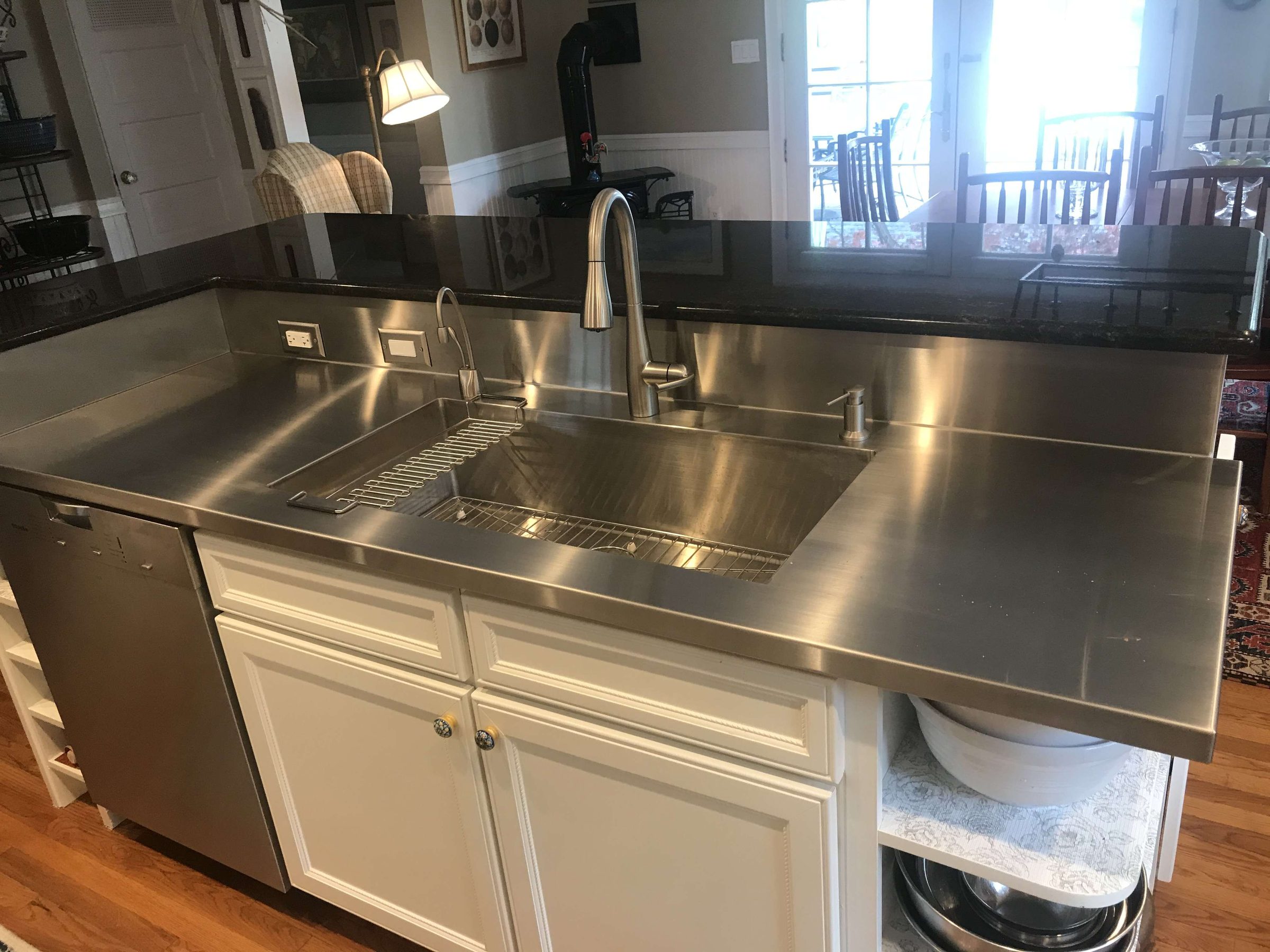 Stainless steel countertop with integrated sink and backsplash by Custom Metal Home