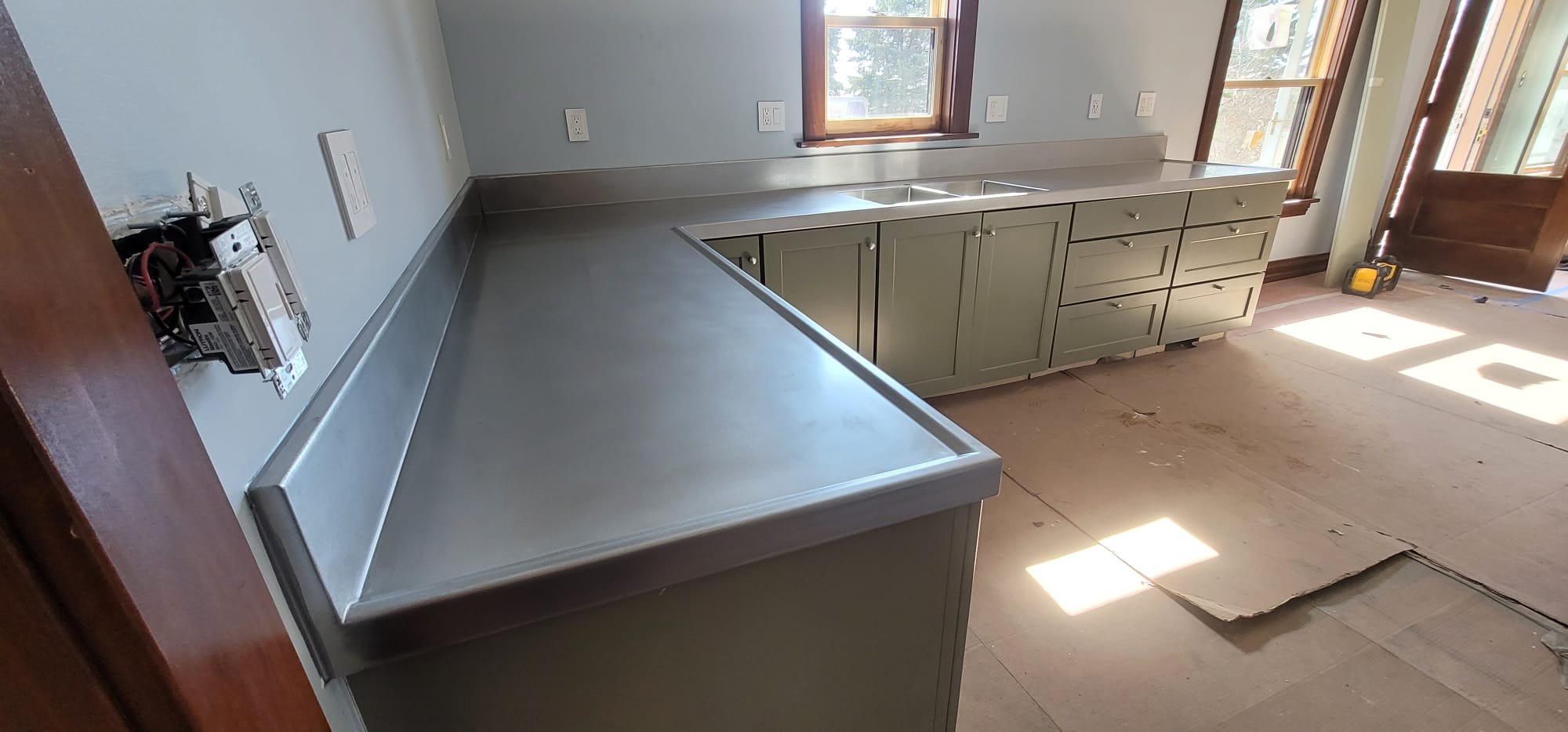 Stainless steel L-shaped countertop with a marine edge and integrated backsplash, Custom Metal Home